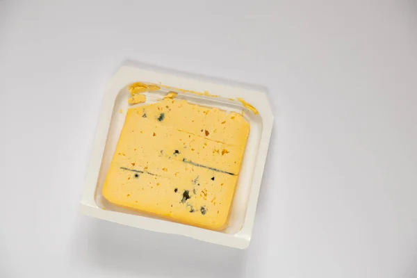 単離された背景に青色のカビを持つ黄色のチーズの一部を閉じる — ストック写真