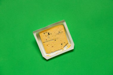 İzole edilmiş arka planda mavi küflü bir parça sarı peynir yakın plan