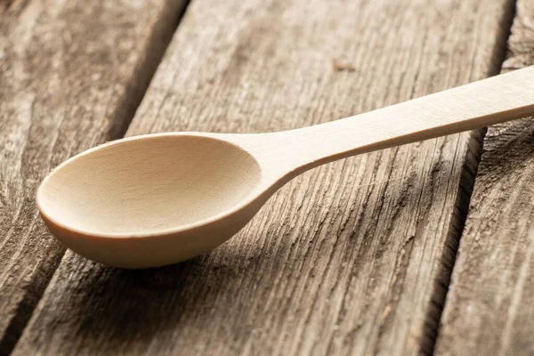empty wooden spoon lies on a wooden table close-up
