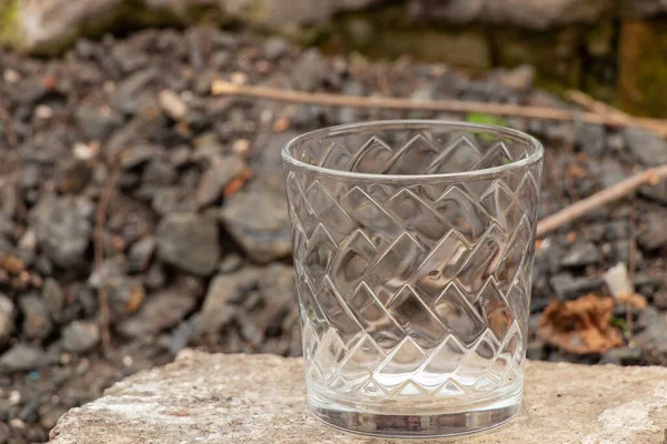 在大街上 白天把透明的空玻璃杯放在石头上 — 图库照片