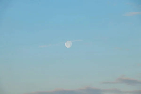 full moon in the morning at dawn in the blue sky close up