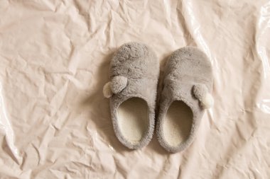 Gri, kapalı, yumuşak, sıcak ayakkabılar bej bir arka planda duruyor.