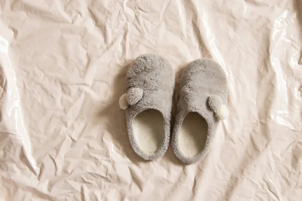 gray indoor soft warm shoes stands on a beige background close-up