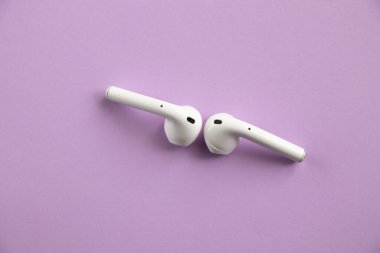 izole edilmiş renkli arka planda kablosuz kulaklıklar.