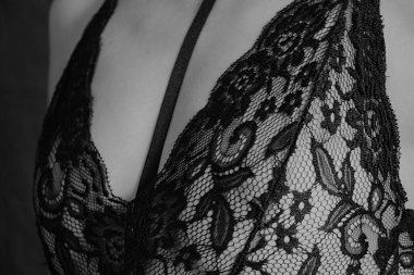 Dantelli siyah iç çamaşırlı genç kız izole bir geçmişe yakın duruyor.