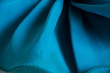 Tasarım için arkaplan olarak dalgalar halinde mavi ipek kırışık kumaş