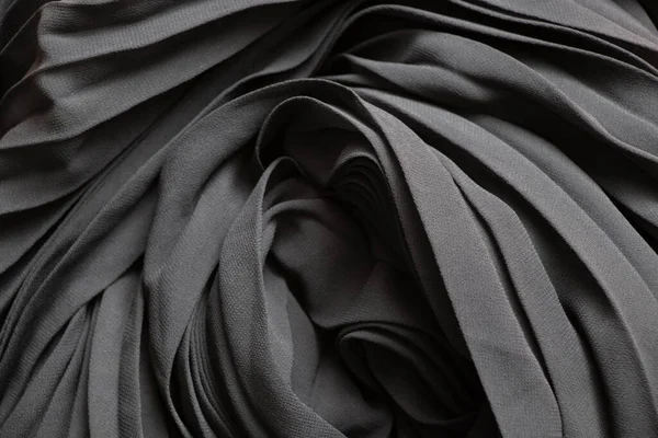 black wavy flowing fabric as background close-up