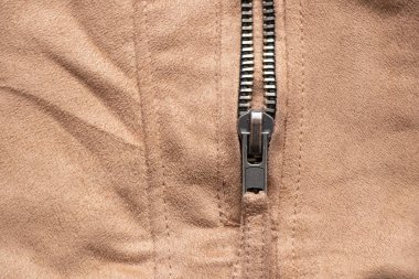 Arkadaki yakın plan olarak kahverengi kumaşta fermuar