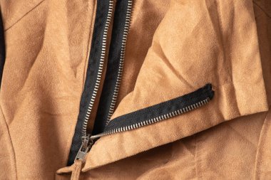 Arkadaki yakın plan olarak kahverengi kumaşta fermuar