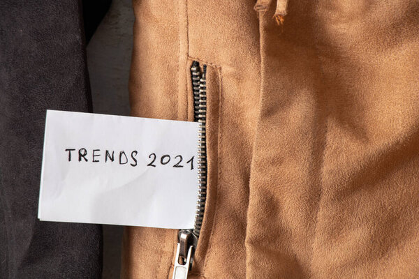 Trends of 2021 written on a piece of paper in the pocket of a brown jacket