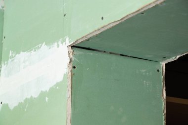 Yenileme sırasında bir odada yeşil alçıdan duvar, bir dairenin yenilenmesi, arka plan olarak alçı pano, bir apartmanda yenileme.