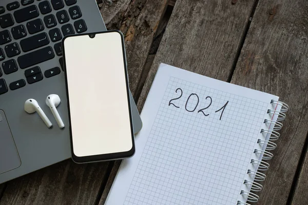 Telefon Laptopa Białym Ekranem Słuchawki Leży Notebooku Tekstem 2021 Plan — Zdjęcie stockowe