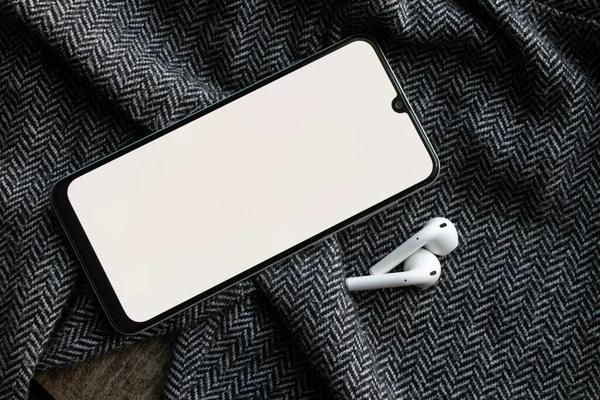 Teléfono Con Auriculares Inalámbricos Con Pantalla Blanca Tela Gris Tecnología —  Fotos de Stock