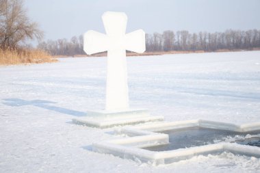 Dinyeper 'de buz çukurlarının yanında buz üzerinde bir buz haçı var. Dnipro şehrindeki Ukrayna' da Epifani gününde dalış yapmak için.