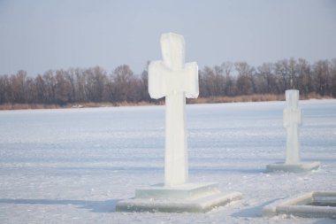 Dinyeper 'de buz çukurlarının yanında buz üzerinde bir buz haçı var. Dnipro şehrindeki Ukrayna' da Epifani gününde dalış yapmak için.