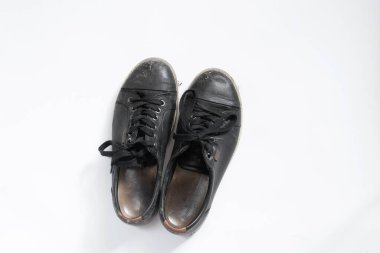 Beyaz arka planda kirli siyah deri kadın ayakkabıları.