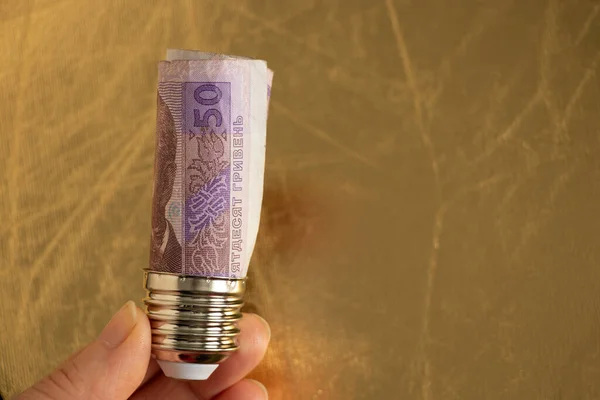 50 Hryvnia banknotlu lamba tutacağı sarı arka plandaki bir kadının elinde vidalanmış, elektrik fiyatı.