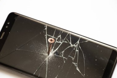 Dokunmaya duyarlı siyah bir cep telefonunun ekranına vida vidalanır. Bozuk bir telefon.