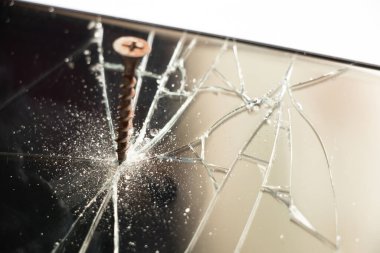 Dokunmaya duyarlı siyah bir cep telefonunun ekranına vida vidalanır. Bozuk bir telefon.