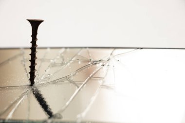 Dokunmaya duyarlı siyah bir cep telefonunun ekranına vida vidalanır. Bozuk bir telefon.