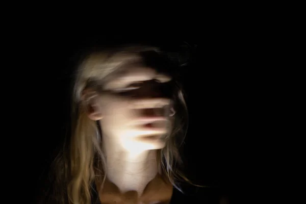 Bir kızın yüzü karanlıkta hareketli uzun bir pozda