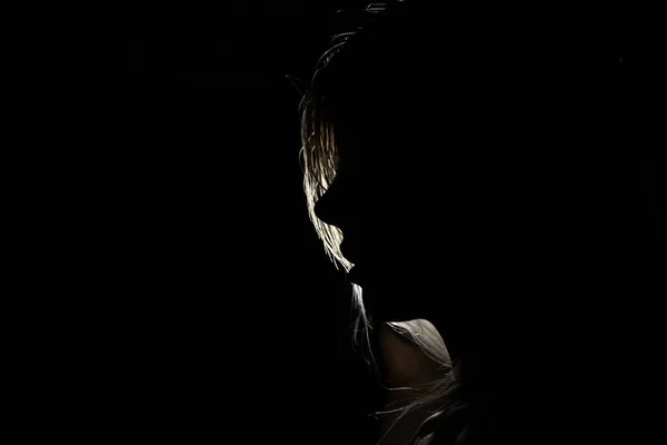 Yüzü uzun saçlı, yüzü siluetli bir kızın yüzü.