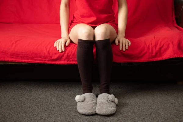 Mädchen Sitzt Socken Und Hausschuhen Auf Rotem Sofa Hause Urlaub — Stockfoto