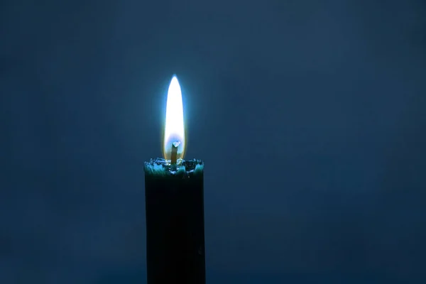 Llama Una Vela Encendida Sobre Fondo Borroso Azul —  Fotos de Stock