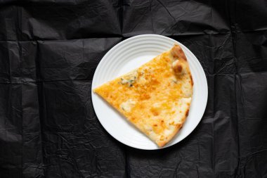 Öğle yemeği için masada bir dilim vegan peynirli pizza.