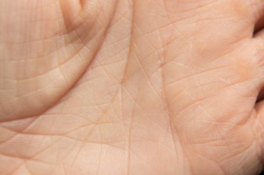 Arka plan makro fotoğrafı olarak genç bir kızın eli, vücudun yakın plan fotoğrafı.