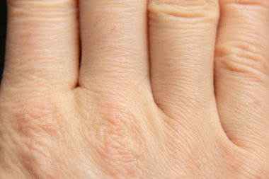 Arka plan makro fotoğrafı olarak genç bir kızın eli, vücudun yakın plan fotoğrafı.