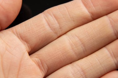 Arka plan makro fotoğrafı olarak genç bir kızın eli, vücudun yakın plan fotoğrafı.