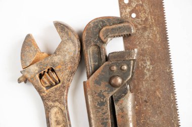 Ayarlanabilir gaz anahtarı ve paslı testere beyaz arka planda yakın çekim