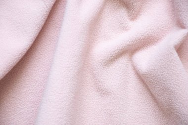Arka planda yakın plan olarak soluk pembe tüylü kırışık kumaş