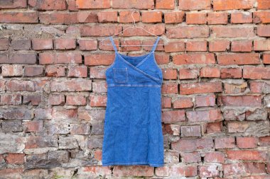 Kot mavisi kadınlar sokakta duvara asılmış bir elbise, moda kadın kıyafetleri.