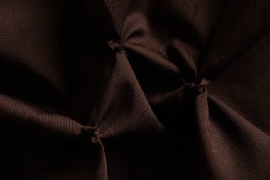 Arkaplanda yakın plan olarak koyu kahverengi kırışık kumaş