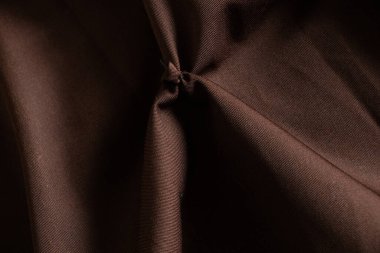 Arkaplanda yakın plan olarak koyu kahverengi kırışık kumaş