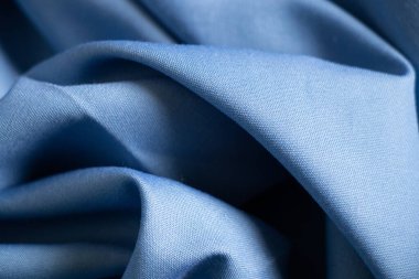 Arkaplanda yakın plan olarak açık mavi buruşuk kumaş