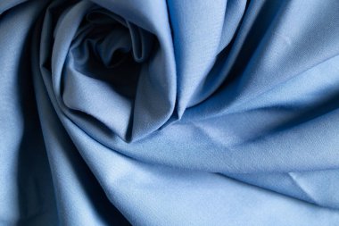 Arkaplanda yakın plan olarak açık mavi buruşuk kumaş