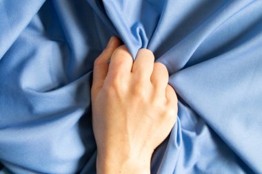 Kadın eli, mavi bir bezi yumruğa, yumruğa, güç öfkesine sıkar.