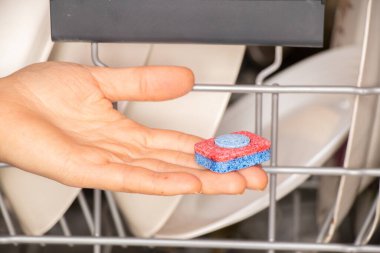 Kadın eli bulaşık makinesi için tablet tutuyor kirli tabaklar, bulaşık makinesi, bulaşık makinesi, bulaşık yıkama.