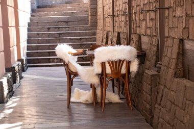 Boş bir odada beyaz kürk battaniyeli ahşap sandalyeler, ahşap mobilyalar, yatakhane dekorasyonu.