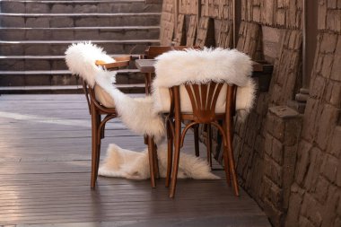 Boş bir odada beyaz kürk battaniyeli ahşap sandalyeler, ahşap mobilyalar, yatakhane dekorasyonu.