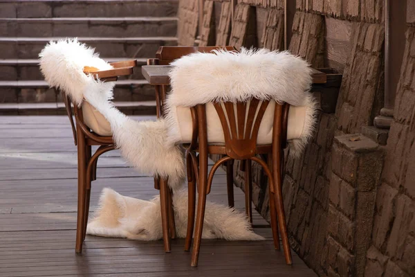 Boş bir odada beyaz kürk battaniyeli ahşap sandalyeler, ahşap mobilyalar, yatakhane dekorasyonu.