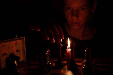 Mum ışığında satranç oynayan, satranç oynayan bir kız.