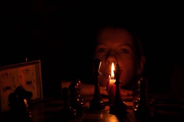 Mum ışığında satranç oynayan, satranç oynayan bir kız.