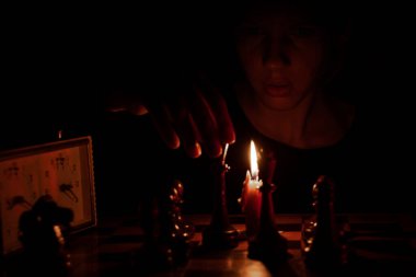 Mum ışığında satranç oynayan, satranç oynayan bir kız.