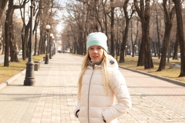 Genç bir kız kışın Ukrayna 'nın Dnipro şehrinin merkezinde güneşli bir günde yürür.