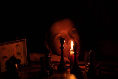 Mum ışığında satranç oynayan, satranç oynayan bir kız.