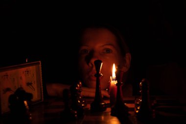 Mum ışığında satranç oynayan, satranç oynayan bir kız.